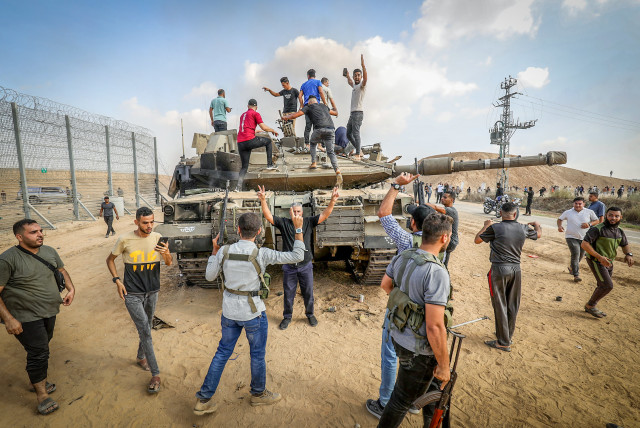 Palestinians take control of an Israeli tank after crossing the border fence with Israel from Khan Yunis in the southern Gaza Strip, October 7, 2023.  (credit: ABED RAHIM KHATIB/FLASH90)