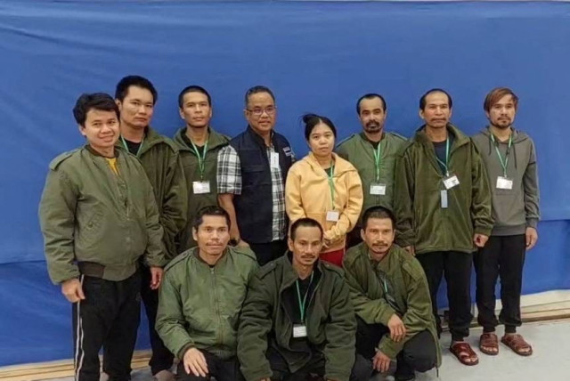  Thai workers taken hostage by Hamas and later released as part of a deal between Israel and Palestinian terrorist group Hamas, pose with a member of Thai mission after a medical checkup, in Tel Aviv, Israel, in this handout image released on November 25, 2023. (credit: Ministry Of Foreign Affairs Thailand/Handout via REUTERS)