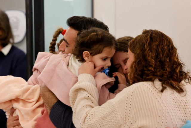 Aviv Asher, 2,5-year-old, her sister Raz Asher, 4,5-year-old, and mother Doron, react as they meet with Yoni, Raz and Aviv's father and Doron's husband after they returned to Israel to the designated complex at the Schneider Children's Medical Center, during a temporary truce between Hamas and Israe (credit: Schneider Children's Medical Center Spokesperson/Handout via REUTERS)
