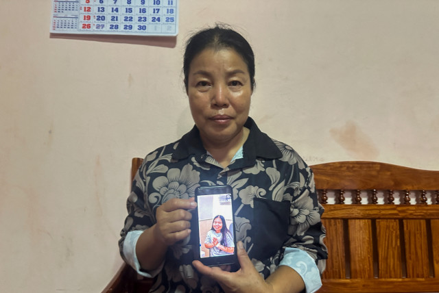 Bunyarin Srijan, the mother of a Thai hostage released as part of a hostages-prisoners swap deal between Hamas and Israel, holds her phone showing an image of her daughter, Natthawaree Mulkan, during an interview at her home in Khon Kaen, Thailand November 25, 2023. (credit:  REUTERS/Napat Wesshasartar)
