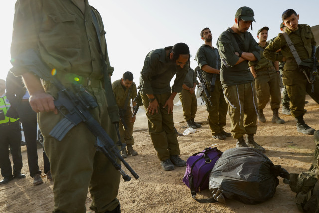  Israeli soldiers pray near the Israel-Gaza border on its Israeli side during a temporary truce between Hamas and Israel, in southern Israel, November 26, 2023 (credit: REUTERS/ALEXANDER ERMOCHENKO)