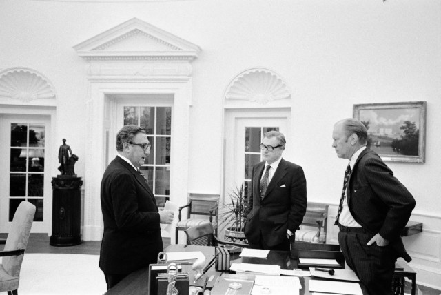  U.S. President Gerald Ford, Nelson A. Rockefeller and Henry A. Kissinger stand around the Oval Office desk prior to walking to the Roosevelt Room for a National Security Council Meeting on the the situation in South Vietnam, at the White House in Washington DC, U.S., April 28, 1975.  (credit: Gerald R. Ford Library/Handout via REUTERS)