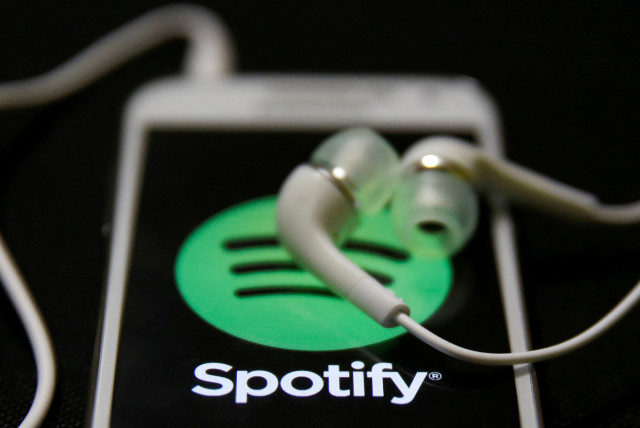Earphones are seen on top of a smart phone with a Spotify logo on it, in Zenica February 20, 2014.