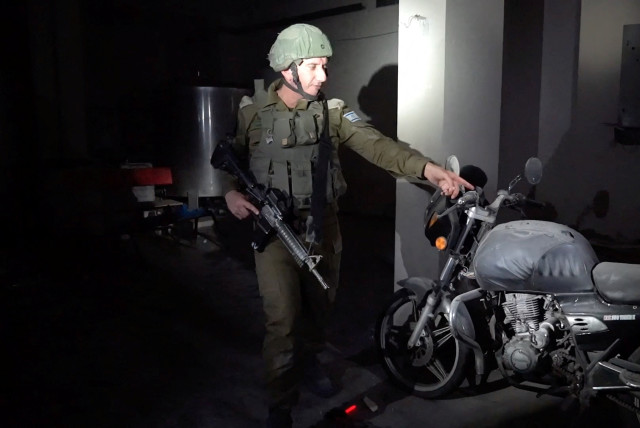 Ο εκπρόσωπος του ισραηλινού στρατού, υποναύαρχος Ντάνιελ Χαγκάρι δείχνει μια μοτοσυκλέτα με σημάδια πυροβολισμών, η οποία, όπως είπε, χρησιμοποιήθηκε για να φέρει ομήρους στη Γάζα μετά την αιφνιδιαστική επίθεση στις 7 Οκτωβρίου (πίστωση φωτογραφίας: REUTERS/IDF HANDOUT)
