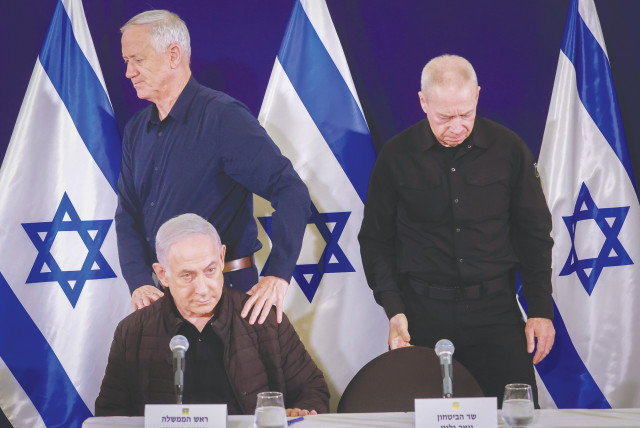  Minister-without-portfolio Benny Gantz walks behind Prime Minister Benjamin Netanyahu, as Defense Minister Yoav gallant takes his seat, at a recent news conference. (credit: MARC ISRAEL SELLEM/THE JERUSALEM POST)
