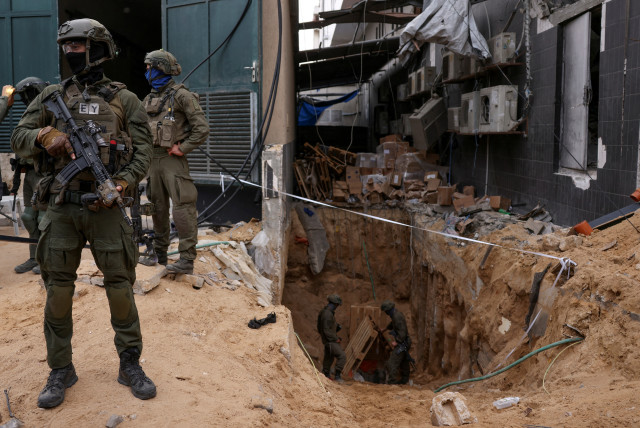  Israeli soldiers stand near the opening to a tunnel at Al Shifa Hospital compound in Gaza City, amid the ongoing ground operation of the Israeli army against Palestinian terrorist group Hamas, in the Gaza Strip, November 22, 2023. (credit: REUTERS/Ronen Zvulun)