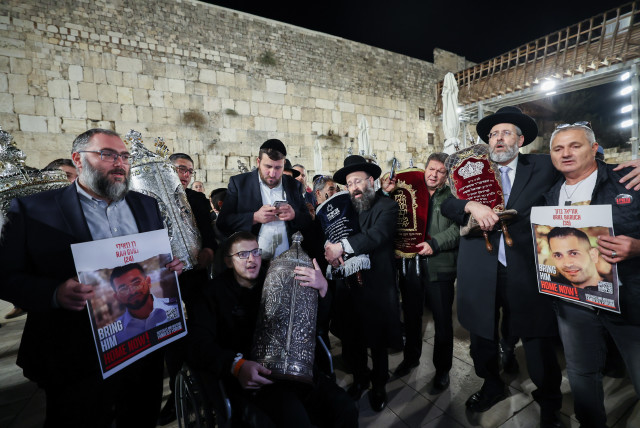 Haredi Jews dance with two new Torah scrolls dedicated to the return of the hostages and in memory of the civilians and soldiers killed in the Oct. 7 massacre, and ongoing war, at the Western Wall in Jerusalem's Old City, November 21, 2023. (credit: YONATAN SINDEL/FLASH90)