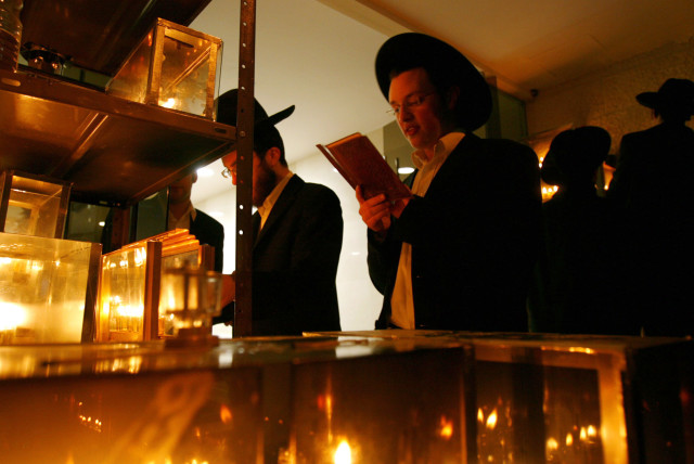  Students from the Mir Yeshiva, a Jewish learning seminary, recite prayers while lighting candles for the Jewish holiday of Hanukkah in the Mea Shearim neighbourhood of Jerusalem (credit: REUTERS/RONEN ZVULUN (JERUSALEM))