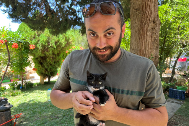  Reuters visuals journalist Issam Abdallah holds a kitten while posing for a picture in Saaideh, Lebanon, July 4, 2023. (credit: REUTERS/EMILIE MADI)