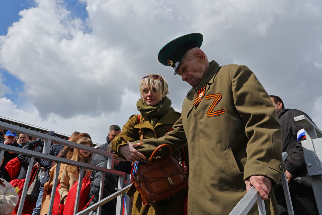 A veteran wearing a St. George's Ribbon, forming the symbol ''Z'' in support of the Russian armed forces involved in a conflict in Ukraine, walks after a military parade on Victory Day, which marks the 77th anniversary of the victory over Nazi Germany in World War Two, in Red Square in central Moscow, (credit: EVGENIA NOVOZHENINA/REUTERS)