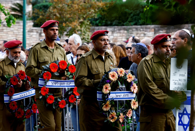  Israeli soldiers carry flowers at the funeral for Israeli reserve soldier Master Sergeant Omri Ben Shachar, who was killed during the ongoing ground operation by Israel's military against Hamas in Gaza, at Kiryat Shaul cemetery in Tel Aviv, Israel, December 10,  (credit: REUTERS/CLODAGH KILCOYNE)