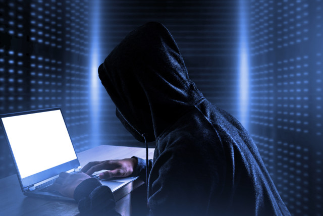  An illustrative image of a person at a computer surrounded by code, indicating hacking or cyberattacks. (credit: INGIMAGE)