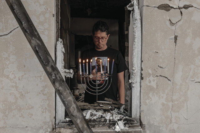  ‘A POWERFUL reminder of the resilience and hope that dwell within us all.’ Yuval Haran, a resident of Kibbutz Be’eri, returned to his home this week and lit a hanukkiah that was retrieved from the rubble.  (credit: CHEN SCHIMMEL)