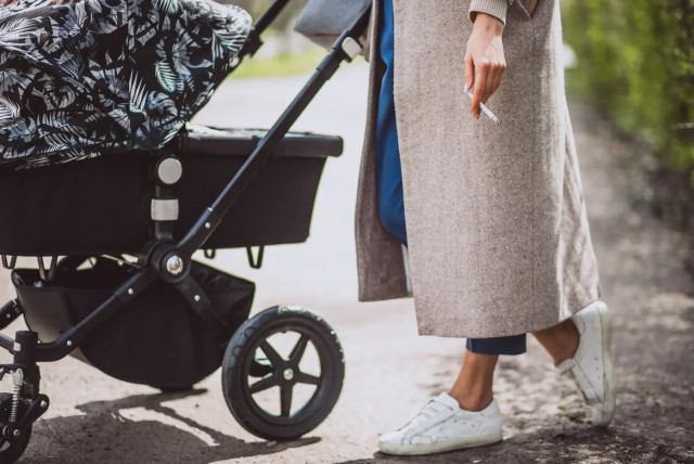 A young mother with a cigarette and a baby stroller (credit: SHUTTERSTOCK)