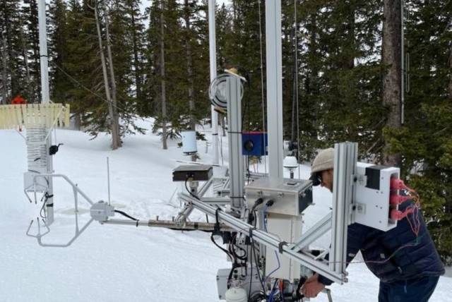  Graduate student Ryan Szczerbinski examines instrumentation called a differential emissivity imaging disdrometer developed by University of Utah. The equipment measures the hydrometeor mass, size, and density of snowflakes. (credit:  Tim Garrett/University of Utah)