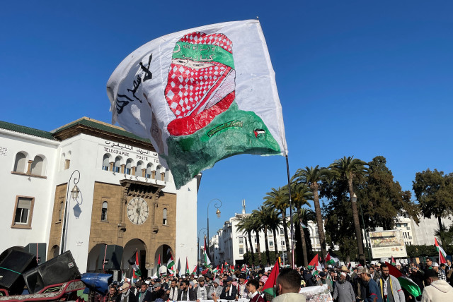  Protesters display a flag with an image of a Palestinian militant, at a demonstration calling for an end to Morocco's ties with Israel, amid the ongoing conflict between Israel and Hamas, in Rabat, Morocco December 24, 2023.  (credit: REUTERS/Ahmed El Jechtimi)