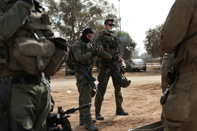  An Israeli soldier looks at his phone, December 25, 2023 (credit: REUTERS/VIOLETA SANTOS MOURA)
