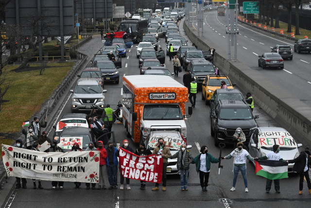 Pro-Palestinian demonstrators block traffic on the road that leads to John F Kennedy airport (JFK), amid the ongoing conflict between Israel and the Palestinian terrorist group Hamas, in New York City, US. December 27, 2023. (credit: REUTERS/STEPHANIE KEITH)