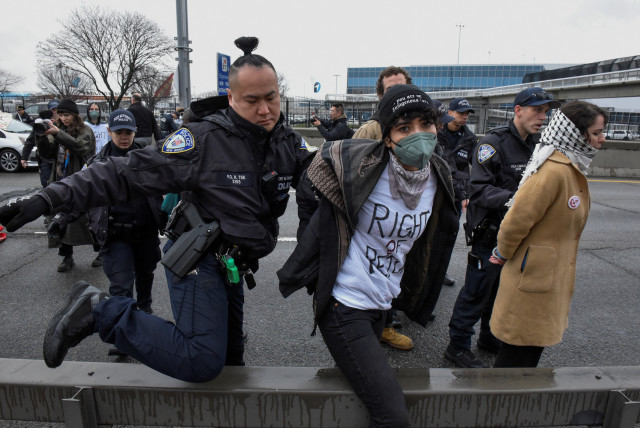 Pro-Palestinian demonstrators are detained by Port Authority police after blocking traffic on the road that leads to John F Kennedy airport (JFK), amid the ongoing conflict between Israel and the Palestinian terrorist group Hamas, in New York City, US. (credit: STEPHANIE KEITH/REUTERS)