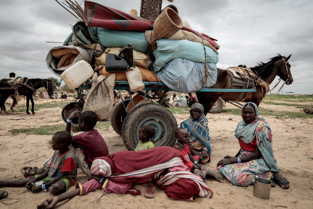  A Sudanese family who fled the conflict in Murnei in Sudan's Darfur region, sit beside their belongings while waiting to be registered by UNHCR upon crossing the border between Sudan and Chad in Adre, Chad, July 26, 2023.  (credit: REUTERS/ZOHRA BENSEMRA)