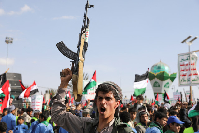  A man holds up a gun, as Houthi supporters rally to commemorate ten Houthi fighters killed by the US Navy in the Red Sea, in Sanaa, Yemen January 5, 2024 (credit: REUTERS/KHALED ABDULLAH)