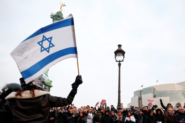  A woman waves an Israeli flag as people gather during the event ''100 days 100 voices'' to mark 100 days since the October 7 Hamas attack, calling for the release of Israeli hostages in Gaza, in front of the Opera Bastille in Paris, France, January 14, 2024 (credit: REUTERS/GONZALO FUENTES)