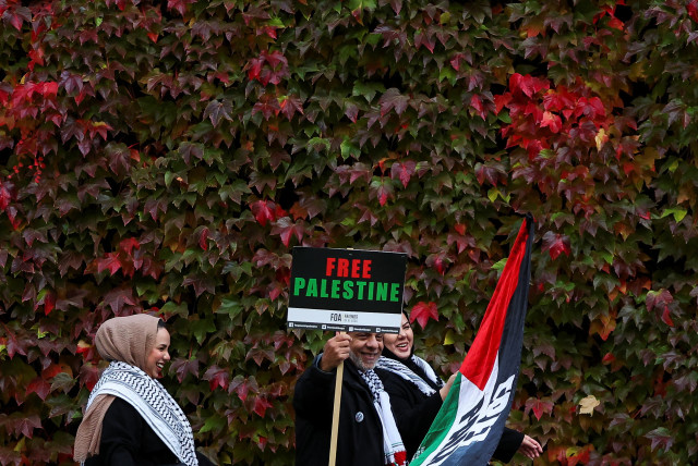  Pro-Palestinian protesters pose with autumn foliage in the background near the rally held in solidarity with Palestinians in Gaza, amid the ongoing conflict between Israel and the Palestinian Islamist group Hamas, in London, Britain, November 4, 2023.  (credit: REUTERS/TOBY MELVILLE)