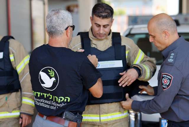  a firefighter receives a vest from IFCJ members (credit: GUY YECHIELI, IFCJ)