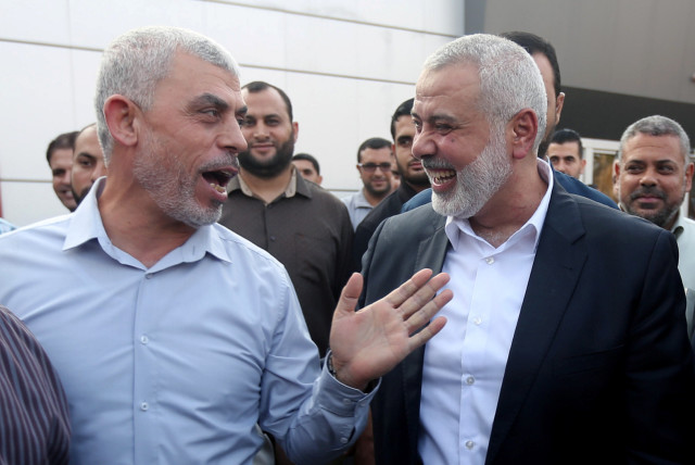  Hamas Gaza Chief Yahya Sinwar (L) gestures as he speaks with Hamas chief Ismail Haniyeh at the Rafah border crossing in the southern Gaza Strip September 19, 2017 (credit: REUTERS/IBRAHEEM ABU MUSTAFA)