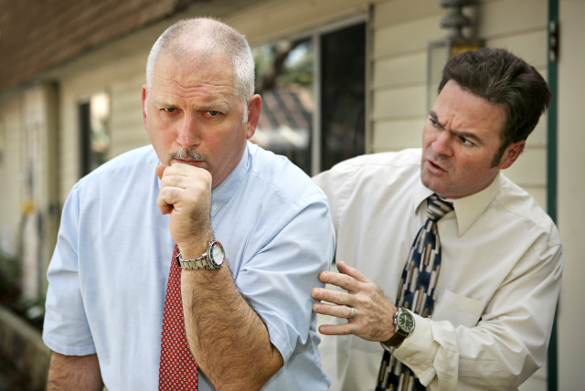  An older businessman is seen coughing in the office in this illustrative photo. (credit: INGIMAGE)