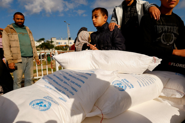 Palestinians receive flour bags distributed by UNRWA in Rafah, in the southern Gaza Strip November 21, 2023. (credit: REUTERS/IBRAHEEM ABU MUSTAFA)