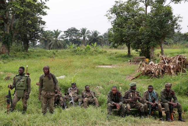  Armed Forces of the Democratic Republic of the Congo (FARDC) soldiers rest next to a road after Islamist rebel group called the Allied Democratic Forces (ADF) attacked area around Mukoko village, North Kivu province of Democratic Republic of Congo, December 11, 2018. (credit: GORAN TOMASEVIC/REUTERS)