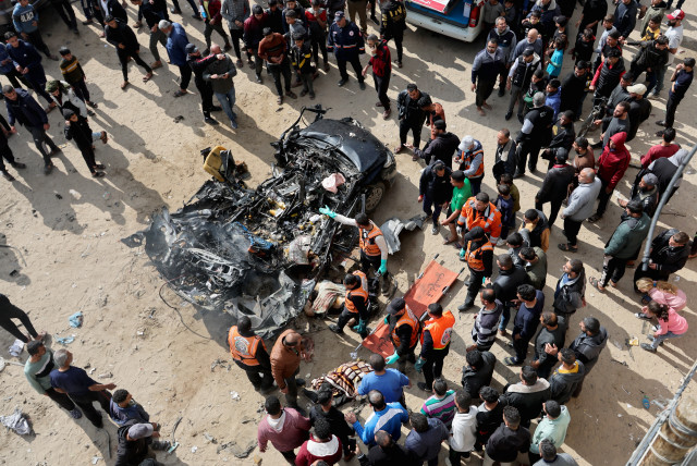  Palestinians inspect a car hit by an Israeli strike, amid the ongoing conflict between Israel and Palestinian Islamist group Hamas, in Rafah in the southern Gaza Strip, February 10, 2024. (credit: REUTERS/IBRAHEEM ABU MUSTAFA)