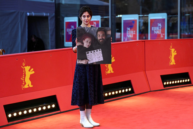  A guest poses with a picture of directors Maryam Moghaddam and Behtash Sanaeeha on the day of the screening of the movie ''My Favourite Cake'' (''Keyke mahboobe man'') at the 74th Berlinale International Film Festival in Berlin, Germany February 16, 2024. (credit: REUTERS/ANNEGRET HILSE)