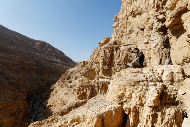  An excavator rests by the entrance to Muraba'at Cave, a desert cliff excavation overseen by the Israel Antiquities Authority, near the Dead Sea in the Israeli-occupied West Bank December 28, 2022 (credit: AMIR COHEN/REUTERS)