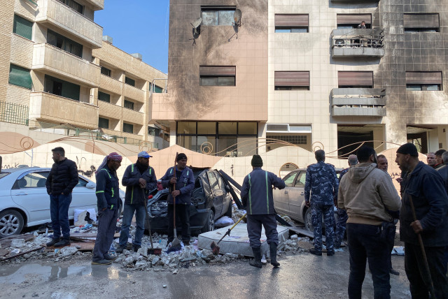  Workers and people stand near a damaged building after, according to Syrian state media reports, several Israeli missiles hit a residential building in the Kafr Sousa district, Damascus, Syria February 21, 2024 (credit: REUTERS/FIRAS MAKDESI)