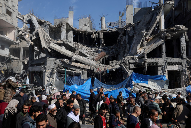  Palestinians shop in an open-air market near the ruins of houses and buildings destroyed in Israeli strikes during the conflict, amid a temporary truce between Hamas and Israel, in Nuseirat refugee camp in the central Gaza Strip November 30, 2023. (credit: IBRAHEEM ABU MUSTAFA/REUTERS)