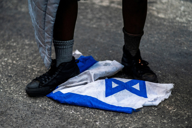  A protester steps on the Israeli flag during a march demanding a ceasefire and the end of Israel's attacks on Gaza, in New York City, U.S., February 22, 2024 (credit: Eduardo Munoz/Reuters)