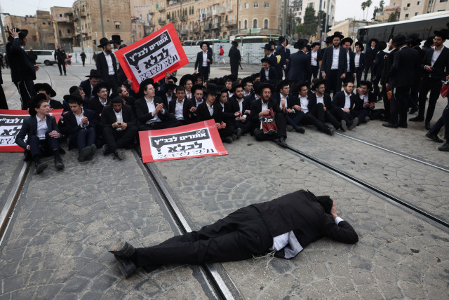 Ultra-Orthodox Jewish men protest against attempts to change government policy that grants ultra-Orthodox Jews exemptions from military conscription in Jerusalem February 26, 2024. (credit: RONEN ZVULUN/REUTERS)