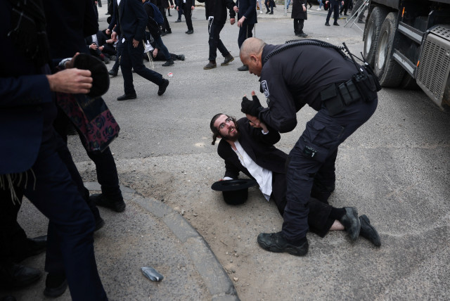 A protester is detained as Ultra-Ortodox Jewish men protest against attempts to change government policy that grants ultra-Orthodox Jews exemptions from military conscription in Jerusalem February 26, 2024. (credit: RONEN ZVULUN/REUTERS)