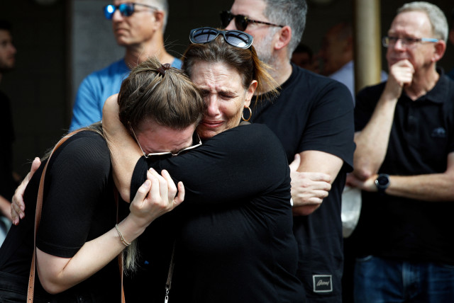 In Kiryat Tivon, family and friends mourn Danielle, 25, and Noam, 26, an Israeli couple who were killed in a deadly attack by Hamas terrorists from Gaza as they attended a festival, as they are buried next to each other at their funeral, October 12, 2023. (credit: REUTERS/SHIR TOREM)