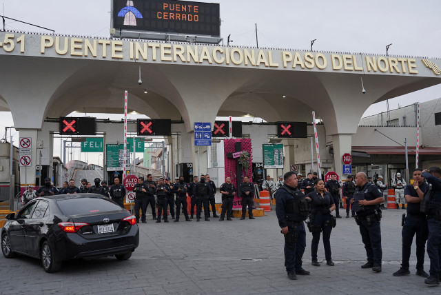  Mexican police stand guard in front of the entrance to the Paso del Norte International Bridge after it was closed by Mexican and U.S. authorities after migrants assembled and forced their way onto the bridge in downtown Ciudad Juarez, Mexico, March 12, 2023. (credit: PAUL RATJE/REUTERS)