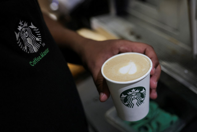  An employee prepares a coffee drink at a Starbucks' outlet at a market in New Delhi, India, May 30, 2023. (credit: REUTERS/ANUSHREE FADNAVIS)