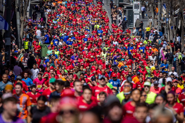  Thousands of runners pound the pavement in Jerusalem’s annual marathon, with part of the race near the Old City walls, March 17, 2023.  (credit: YONATAN SINDEL/FLASH90)