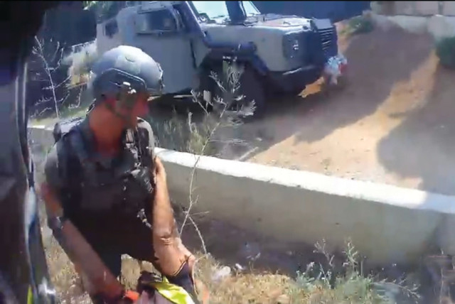  BODYCAM SCREENSHOT of Yosef rescuing a wounded man at 1:12:29 p.m., about an hour before he was killed. (credit: ISRAEL POLICE)