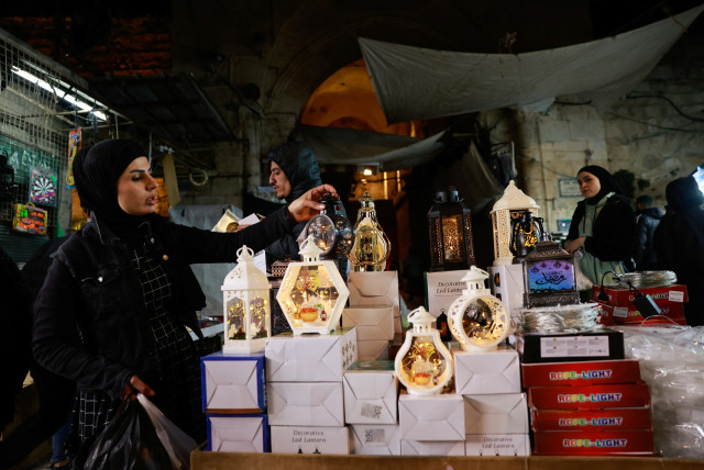  A woman holds a lantern at a market during of the Muslim holy month of Ramadan, in Jerusalem's Old City March 10, 2024.  (credit: AMMAR AWAD/REUTERS)