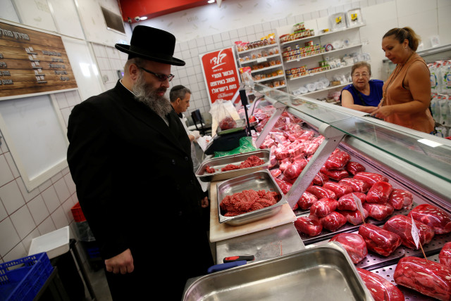  Kosher inspector Aaron Wulkan examines display refrigerators containing meat in a food store to ensure that the food is stored and prepared according to Jewish regulations and customs in Bat Yam, Israel, October 31, 2016. (credit: BAZ RATNER/REUTERS)