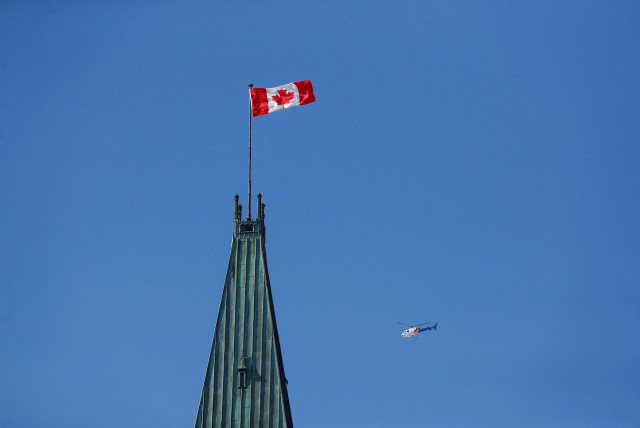   Royal Canadian Mounted Police (RCMP) helicopter flies past the Peace Tower on Parliament Hill, during the visit of U.S. President Joe Biden, in Ottawa, Ontario, Canada March 24, 2023. (credit: Lars Hagberg/Reuters)