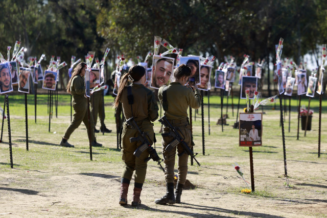  SOLDIERS PAY their respects at the Nova music festival site in November. ‘Beyond the sounds of the shofar, guns, music, prayers, livestock, and bombs, I also heard the whispers,’ says the writer.  (credit: MENAHEM KAHANA / AFP)