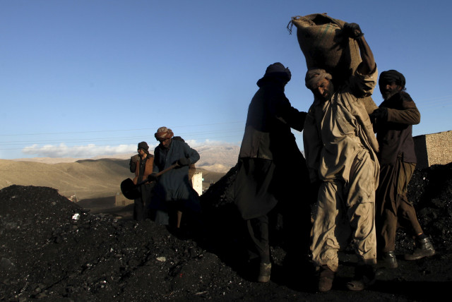  Workers at a coal mine fill sacks of coal to load on a truck outside Quetta, Pakistan December 9, 2015.  (credit: REUTERS/NASEER AHMED)